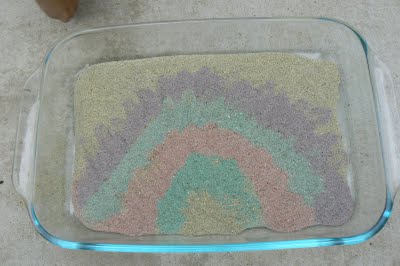 Sand painting a rainbow with beautifully colored sand