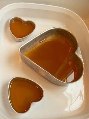 Pouring melted beeswax into the heart moulds