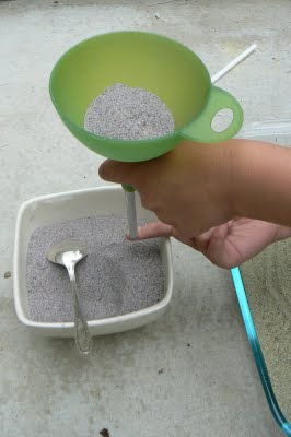 Filling our sand funnel with blue sand for painting with colored sand