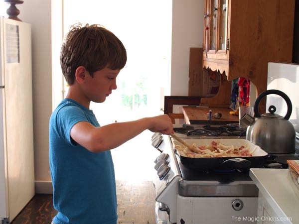 photo of boy cooking bacon and egg pie